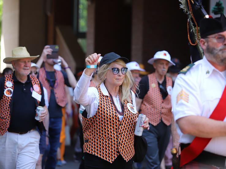 A woman with orange nail polish raises her fist during the P-rade.