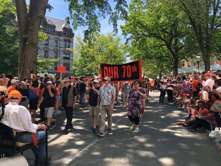 A sign carried in the P-rade reads "Our 70th."