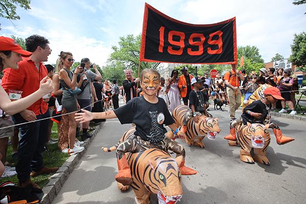 Children "ride" on inflatable tigers with the Class of 1999 in the P-rade.