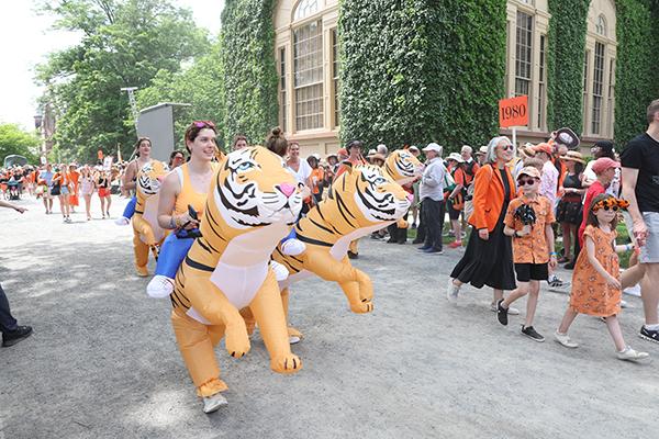 Alumni "ride" big inflatable tigers in the P-rade.