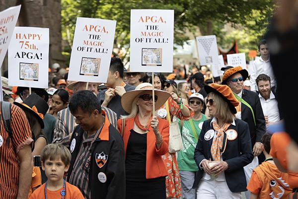 People marching in the P-rade carry signs that read "APGA, the magic of it all!"