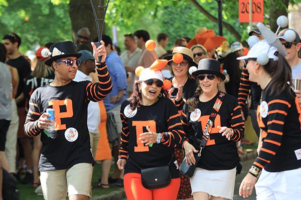 Friends wearing black shirts with the letter "P" in orange march in the P-rade.