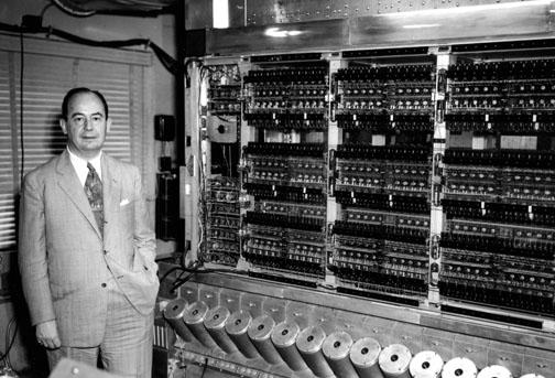 John von Neumann with MANIAC in 1952. The shiny cylinders contained random-access memory, visible as flickering phosphor through the holes.