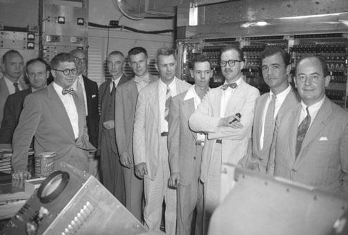 With MANIAC on dedication day in 1952 were Gerald Estrin (third from left), atomic physicist Robert Oppenheimer (fifth from left), and von Neumann (far right).