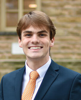 OTC_James Swineheart.jpg James Swineheart in dark blue suit with orange tie in front of Nassau Hall