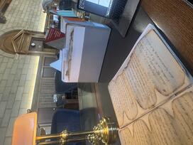 Luke Carroll document.jpeg A yellowed document sits on a wood desk in the National Archives; small lamp is to the left.