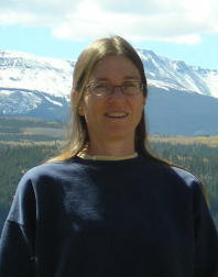 Anne standing in front of snowy mountains.