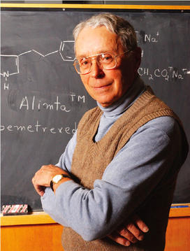  Edward C. Taylor, the A. Barton Hepburn Professor of Organic Chemistry, Emeritus, stands in front of the chemical diagram of Alimta, a powerful cancer-fighting drug that he developed.