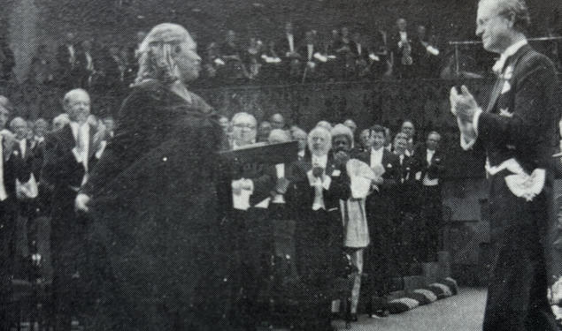 Toni Morrison receives her Nobel Prize from the King of Sweden and acknowledges the applause of the crowd.