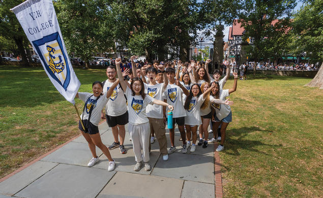 Students wearing Yeh College shirts cheer in front of Fitzrandolph gate.