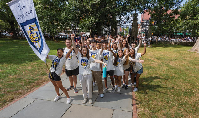 Students wearing Yeh College shirts cheer in front of Fitzrandolph gate.