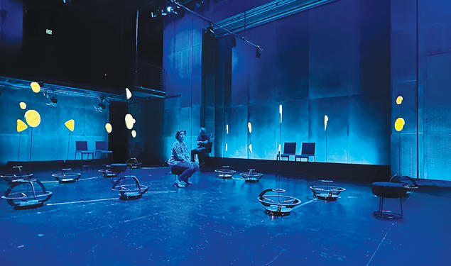 Robots scatter around a room lit with blue light.