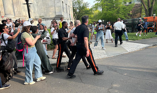 Public Safety police officers walk a man in handcuffs the night in April when student protestors staged a sit-in at Clio.