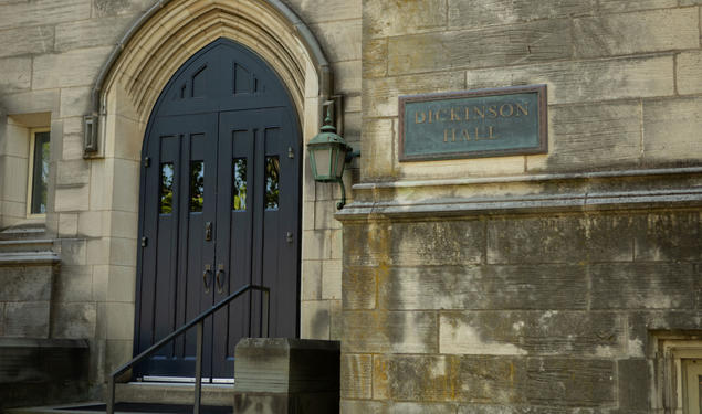 A door on a Gothic building next to a sign reading "Dickinson Hall."