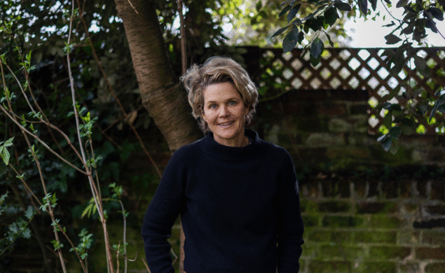 Portrait of Author Eliza Griswold standing in front of greenery. 