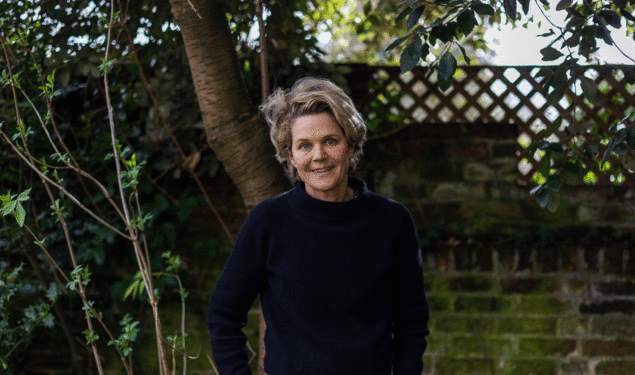 Portrait of Author Eliza Griswold standing in front of greenery. 