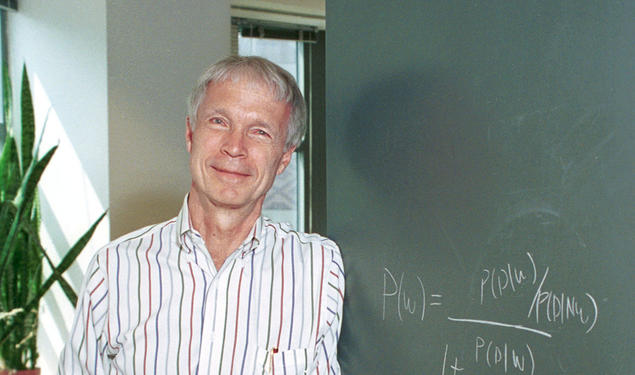 John Hopfield in front of a chalkboard