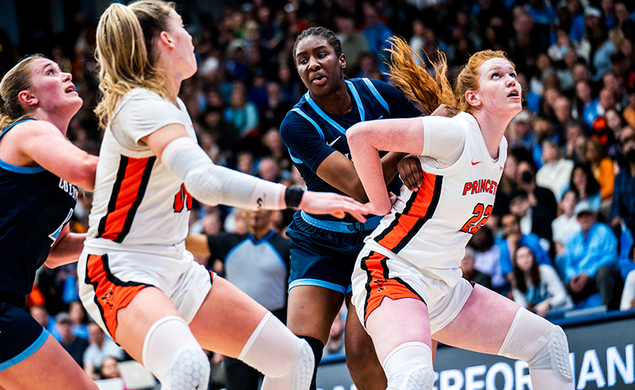 Four players vying for position to rebound the ball in a basketball game