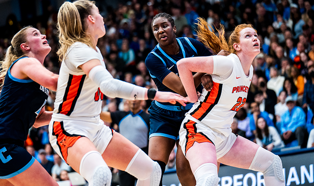 Four players vying for position to rebound the ball in a basketball game