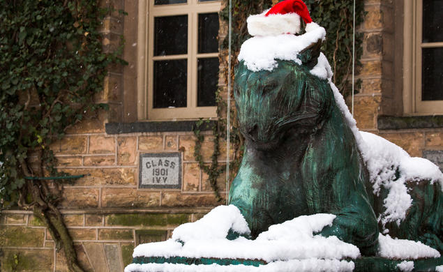 One of Princeton’s bronze tiger statues in the snow wearing a Santa hat.