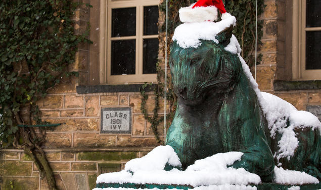 One of Princeton’s bronze tiger statues in the snow wearing a Santa hat.