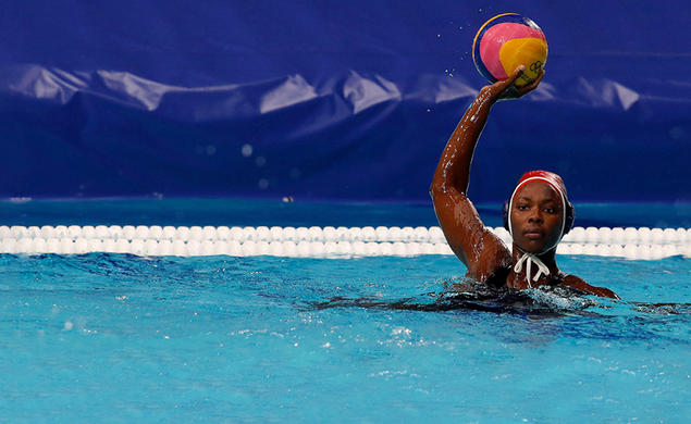 Water polo goalie Ashleigh Johnson ’17 palms the ball in her right hand and holds it over her head.
