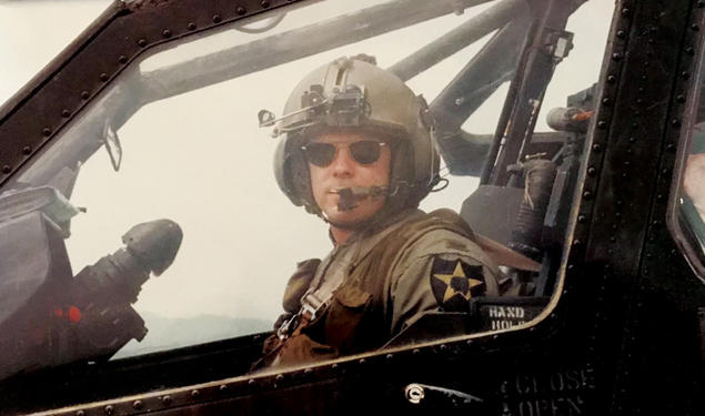 Christopher Hornbarger in military flight uniform piloting a helicopter