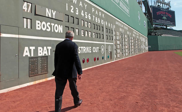 Larry Lucchino ’67 walking along Boston's Green Monster at Fenway Park