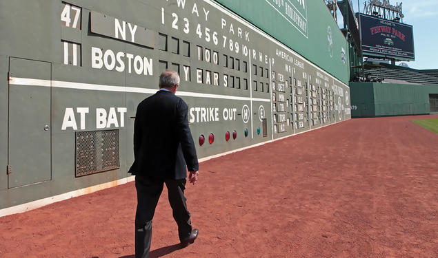 Larry Lucchino ’67 walking along Boston's Green Monster at Fenway Park