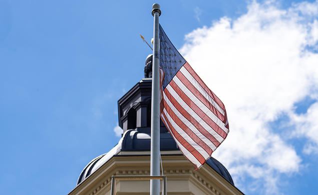 An American flag flies in front of the cupola of Princeton’s Nassau Hall.