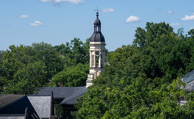 The cupola of Princeton's Nassau Hall peeks up from surrounding leafy trees.