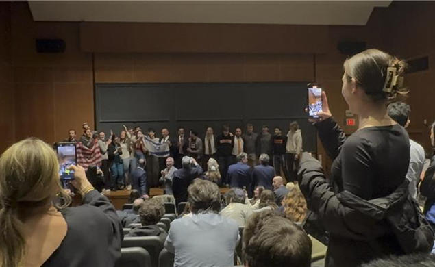 Attendees crowd the stage during an emotional moment during a speech by the former prime minister of Israel.