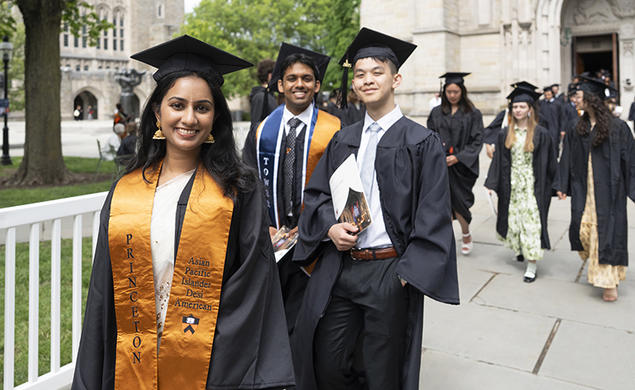 Seniors in their caps and gowns walk out of the University Chapel.