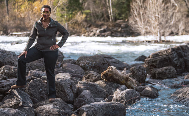 Monica Harris standing on rocks near a swift moving creek in Montana