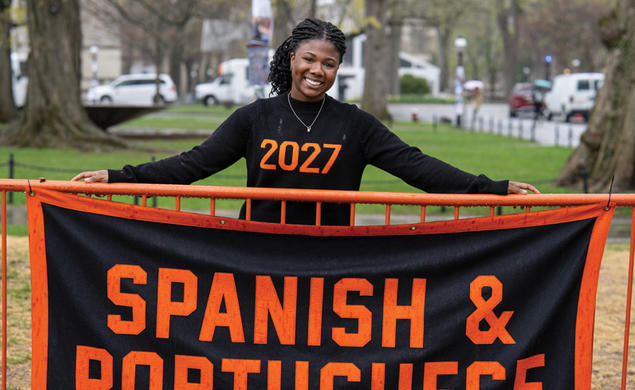 Undergrad Alli Ebanks stands behind the Spanish and Portuguese banner at Declaration Day