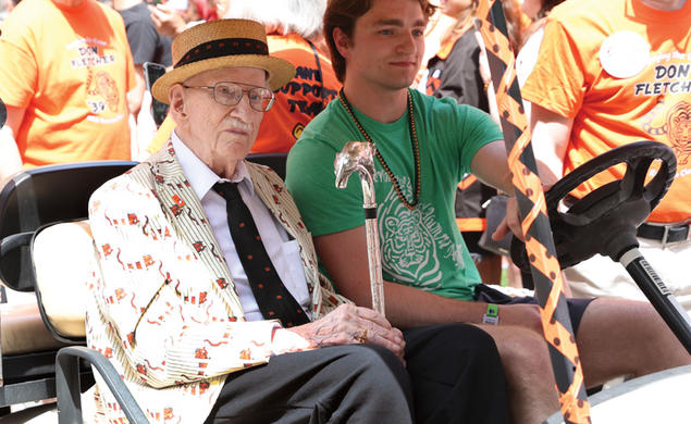 Donald Fletcher ’39 *51 riding in a gold cart during the 2024 P-rade