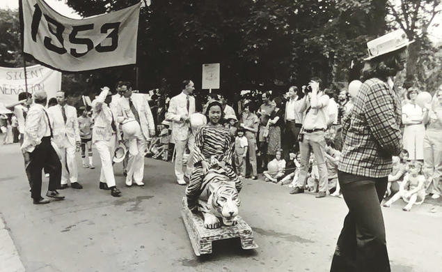 Black and white photo of the 1977 P-rade featuring a little girl dressed in a tiger costume being pulled by a female marcher in front of the Class of 1953 marching