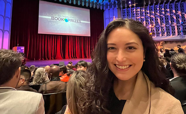 Allison Light ’18 take a selfie with the stage at the Los Angeles Times Book Prizes in the background.