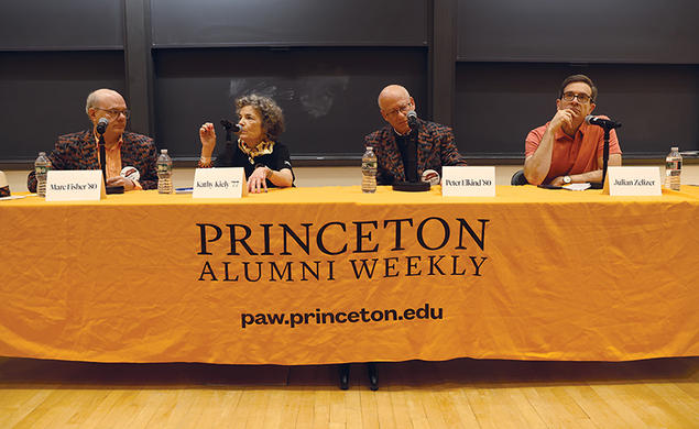 Four people sit behind a table covered with an orange tablecloth that reads "Princeton Alumni Weekly: paw.princeton.edu."