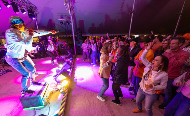 A band playing at the Class of 1995 tent during Reunions with people dancing