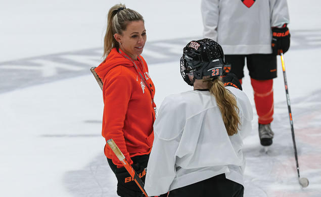 Cara Morey women’s ice hockey head coach talks to a plaey on the ice