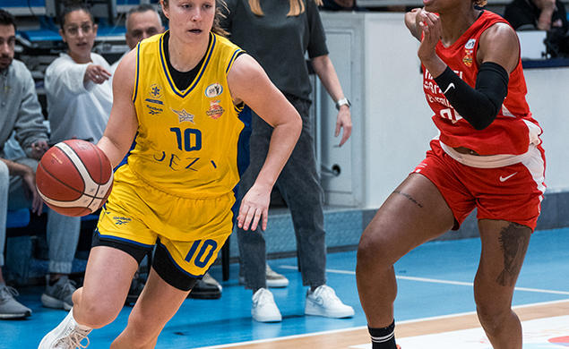 Abby Meyers dribbles a basketball past an opposing player.