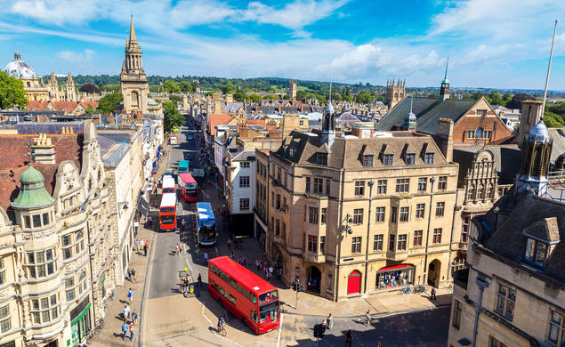 A birds-eye view of Oxford's quaint streets, with a red double-decker bus driving down the middle.