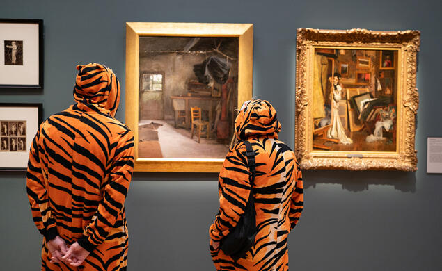 PAUM OPENING_Tigers admire art.jpg Two people dressed in tiger costumes view art on display during opening night at the Princeton University Art Museum.
