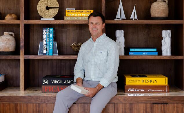Michael-Tibbetts_Tiger-Travels.jpeg Michael Tibbetts sit on a counter in front of a books shelf