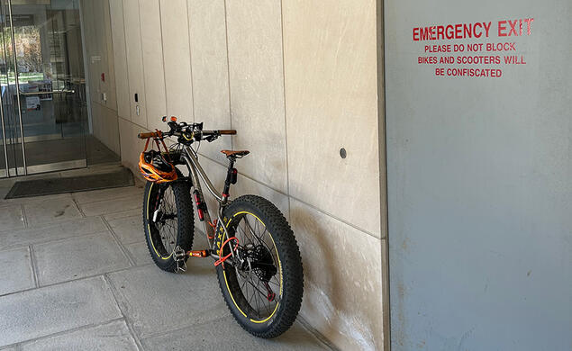 An e-bike leans against a campus building.