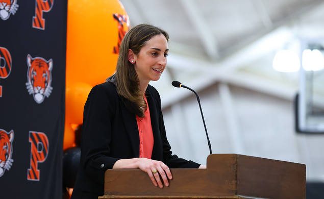Lauren Gosselin speaks into a microphone at a podium in Jadwin Gym