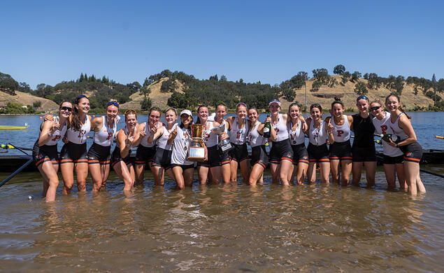 The women&rsquo;s lightweight crew team stands in knee-high water.
