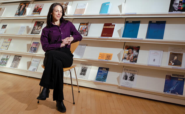 Elizabeth Margulis sitting in a room in front of a row of magazines