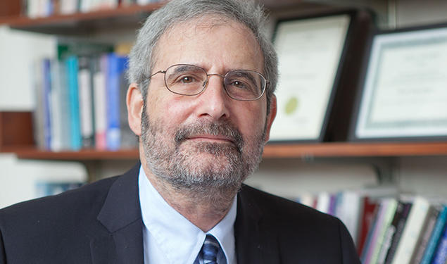 This is a headshot photo of Mark Beissinger, with a bookcase in the background.